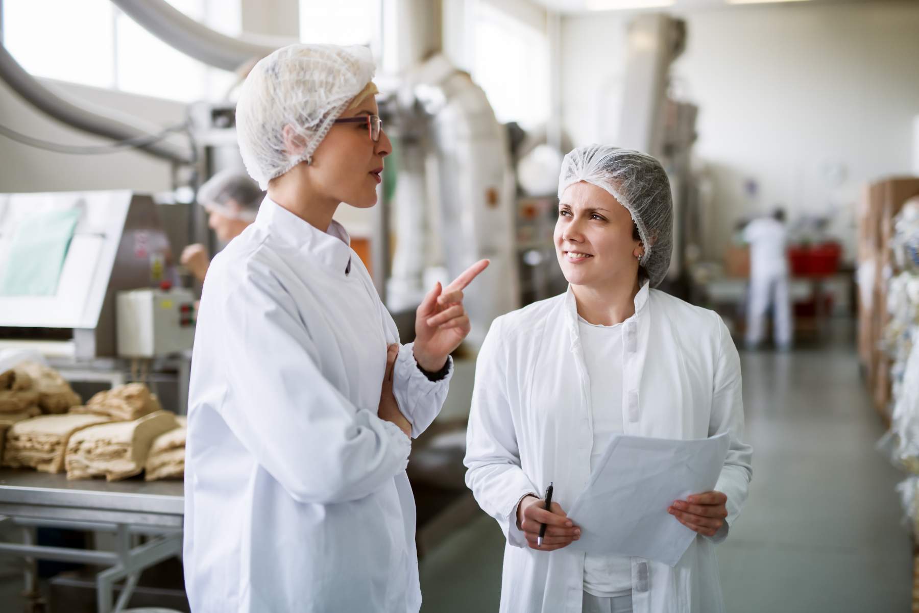 Two employees have discussion on the plant floor